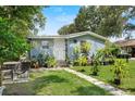 Charming single-story home boasts a well-kept lawn and inviting walkway with many decorative plants at 306 Avenue A E, Winter Haven, FL 33880