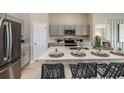 Bright kitchen features stainless steel appliances, gray cabinetry, island with seating, and stylish countertops at 1017 Foreshore Ln, Haines City, FL 33844