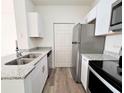 Well-lit kitchen features stainless steel appliances, granite countertops, and modern white cabinetry at 2572 Robert Trent Jones Dr # 1235, Orlando, FL 32835