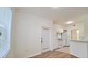 Well-lit living area leading to the kitchen with white appliances and a sliding door with blinds at 2586 Robert Trent Jones Dr # 1124, Orlando, FL 32835