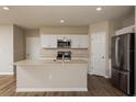 Bright kitchen featuring white cabinetry, stainless steel appliances, and an island with a sink at 4106 Gerbera Daisy Ave, Lake Hamilton, FL 33851