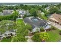 Aerial view of a home with a screened pool, spacious yard, mature trees, and lake in the distance at 1034 Brighton Way, Lakeland, FL 33813