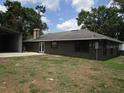 View of the back of the home, featuring a patio and a large backyard at 5190 Starling Dr, Mulberry, FL 33860
