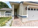 Inviting covered front entry with a brick walkway, exterior lighting, and manicured landscaping at 216 Kingshill Se Ct, Winter Haven, FL 33884