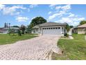 Attractive home featuring a brick driveway and a well-maintained lawn at 216 Kingshill Se Ct, Winter Haven, FL 33884