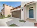 Home exterior featuring a two-car garage, blue front door, and well-maintained lawn at 3067 Princewood Dr, Minneola, FL 34715