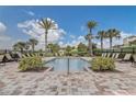 Community pool with lounge chairs, manicured landscaping, and a clear blue sky at 3067 Princewood Dr, Minneola, FL 34715
