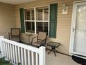 Inviting front porch with comfortable seating and charming shutters, perfect for enjoying the outdoors at 310 Knoll Pl, The Villages, FL 32162