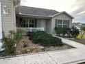 Well manicured front yard with gravel accents, lush shrubbery, and a concrete pathway leading to the entrance at 310 Knoll Pl, The Villages, FL 32162