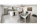 Bright kitchen with stainless steel appliances, center island with a beverage cooler and a stylish dining table at 12844 Oulton Cir, Orlando, FL 32832