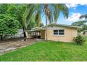 Single-story home with covered parking, lush lawn, and a mature palm tree at 1740 Inman Nw Dr, Winter Haven, FL 33881