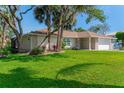 Well-maintained front yard with lush green grass and landscaping surrounding a one-story home with a garage at 64 Alberta Ave, Ponce Inlet, FL 32127