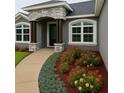 Inviting home exterior with a curved walkway, colorful flowerbeds, and an arched entryway at 7144 Remington Oaks Loop, Lakeland, FL 33810