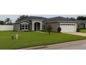Attractive home with a well-manicured lawn, complemented by stone details and a two-car garage at 7144 Remington Oaks Loop, Lakeland, FL 33810