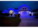 Charming two-story home featuring blue exterior lighting and a well-manicured front yard at 449 Moscato Dr, Davenport, FL 33897