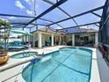 Gorgeous screened-in pool area with a spa and lounge chairs, perfect for relaxation at 449 Moscato Dr, Davenport, FL 33897