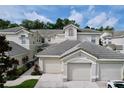 Charming townhouse featuring a tile roof, two-car garage, and well-maintained landscaping at 776 Grasslands Village Cir # 776, Lakeland, FL 33803