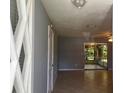 The neutral-toned living room features sleek tile floors and a sliding glass door to a screened in porch at 835 5Th St, Port Orange, FL 32129