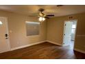 Bright living room with wood-look floors, ceiling fan, and natural light from a window at 1864 Williams Manor Ave, Orlando, FL 32811
