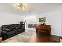 Open-concept living room featuring hardwood floors, a stylish rug, and an adjacent dining area at 3983 Shay Dr, Bartow, FL 33830