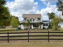 Two story home with a fenced in yard and a covered front porch at 4145 Willis Rd, Mulberry, FL 33860