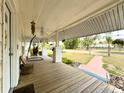 View of the covered front porch with a wood floor, white columns, and a swing at 4145 Willis Rd, Mulberry, FL 33860