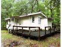 Exterior view of the house featuring a large wooden deck; greenery and trees provide a natural setting at 12828 Sw 49Th Ter, Webster, FL 33597