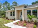 View of front entrance and landscaping of single-story home at 19041 Mardi Gras St, Orlando, FL 32833