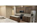 Modern kitchen boasts granite countertops, stainless steel appliances, a stylish backsplash, and an island at 19041 Mardi Gras St, Orlando, FL 32833