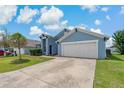 Single-story home featuring a two car garage, tidy lawn and long driveway at 2576 Boots Rd, Lakeland, FL 33810