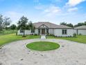 Charming single-story home featuring a well-manicured lawn, circular drive, and inviting exterior at 9419 Alturas Babson Park Cutoff Rd, Bartow, FL 33830