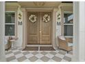Elegant double front doors with decorative wreaths and charming seating area on the porch at 9419 Alturas Babson Park Cutoff Rd, Bartow, FL 33830