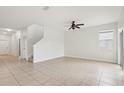 Spacious living room featuring tile flooring, ceiling fan, and staircase access at 1893 Rafton Rd, Apopka, FL 32703