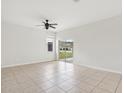 Open living room with tile flooring, ceiling fan, and sliding glass doors to the backyard at 1893 Rafton Rd, Apopka, FL 32703