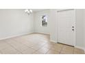 Bright living room with tile flooring, a large window, and a white front door at 1893 Rafton Rd, Apopka, FL 32703