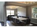 Elegant dining room with a modern chandelier, tray ceiling, and a large table with seating for twelve at 1319 Heavenly Cv, Winter Park, FL 32792