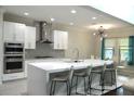 Modern kitchen with sleek white cabinets, stainless steel appliances and waterfall island with seating at 1319 Heavenly Cv, Winter Park, FL 32792