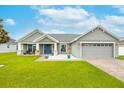 Charming single-story home with a manicured lawn, blue door, and an attached two-car garage at 2053 Charleston Ln, Bartow, FL 33830