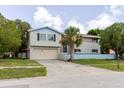 Two-story home with a two car garage, neutral siding, and palm tree at 7072 Scruboak Ln, Orlando, FL 32818