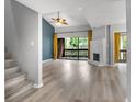 Bright living room with a stone fireplace, wood floors, and sliding doors to the balcony at 1038 E Michigan St # 1, Orlando, FL 32806
