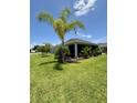 View of a screened-in lanai and beautifully landscaped backyard at 2613 Drew Cir, The Villages, FL 32163