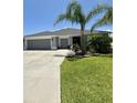 Charming single-story home with a well-manicured lawn and attached two-car garage at 2613 Drew Cir, The Villages, FL 32163