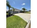 Desirable home featuring a spacious driveway, lush lawn, and well-maintained landscaping at 2613 Drew Cir, The Villages, FL 32163