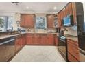 Traditional kitchen with wooden cabinetry, tile floors, modern appliances, and a garden window at 310 Stakes Ct, Deland, FL 32724