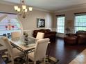 Elegant living room showcasing dark hardwood floors, a glass-top table, and comfortable leather seating at 310 Stakes Ct, Deland, FL 32724