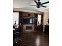 Comfortable living room featuring hardwood floors, an entertainment center, and fireplace at 310 Stakes Ct, Deland, FL 32724