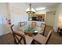 Dining area with round glass table and six chairs, adjacent to kitchen and entryway at 8125 Resort Village Dr # 5902, Orlando, FL 32821