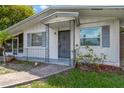 Close up of the home's front entrance, which is painted white and has a secure metal door at 6906 Cocos Dr, Orlando, FL 32807