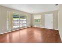 Bright living room featuring a large window with hardwood flooring and a white door at 6906 Cocos Dr, Orlando, FL 32807