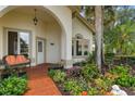 Inviting front porch with colorful flowers, a bench, and beautiful landscaping at 414 Long Cove Ct, Ormond Beach, FL 32174